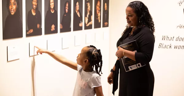 A young girl points to a photo in the BWAG gallery