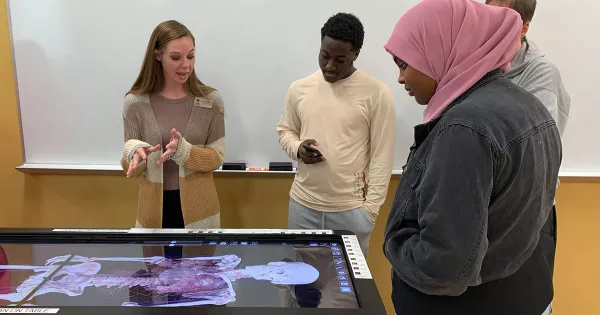 students interacting with an anatomy study table