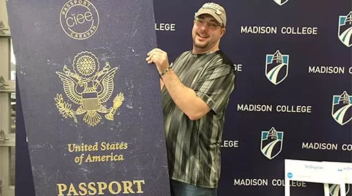 student holding an oversized US passport