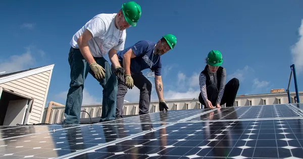 STEM instructors installing solar panels